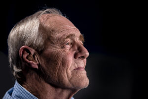 A senior isolated against black, as an example of the health risks that seniors face