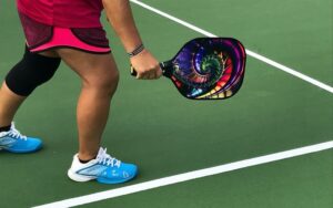 Someone holding a pickleball racket, as an example of pickleball gifts for seniors