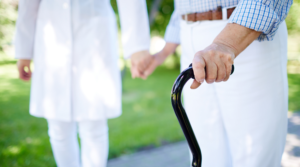 A senior man with a walking stick holding his wife's hand, highlighting the best walking sticks for seniors